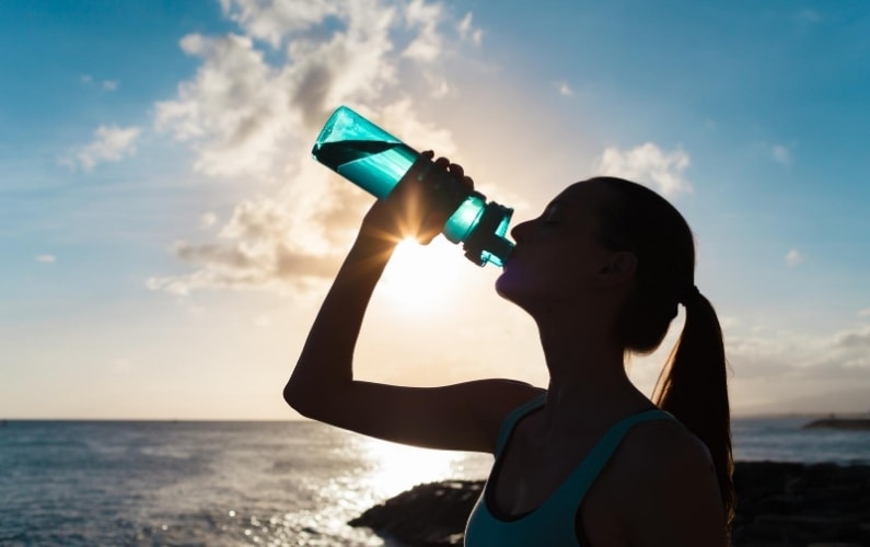 girl drinking water during a heat wave