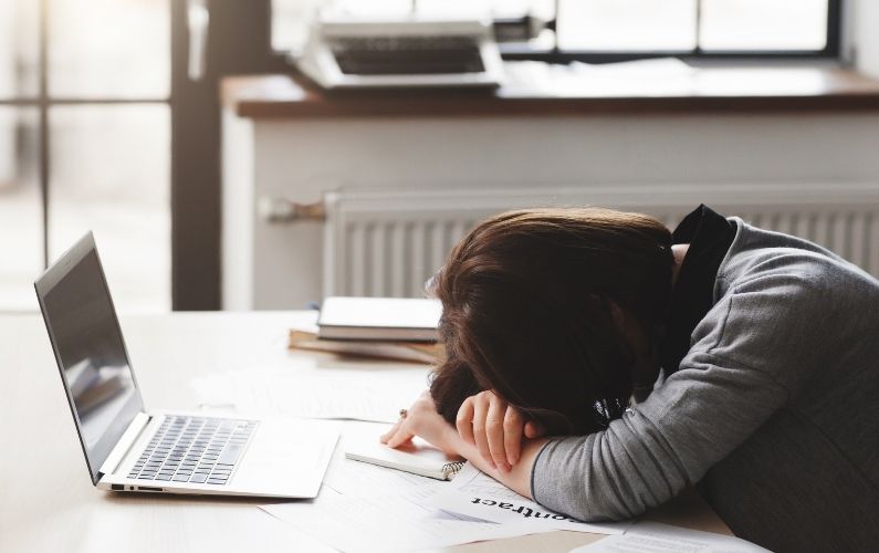 A woman with insomnia sleeping in front of her laptop