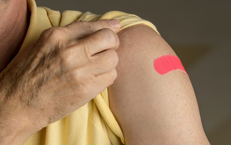 A person with a band-aid on their arm after receiving a vaccine